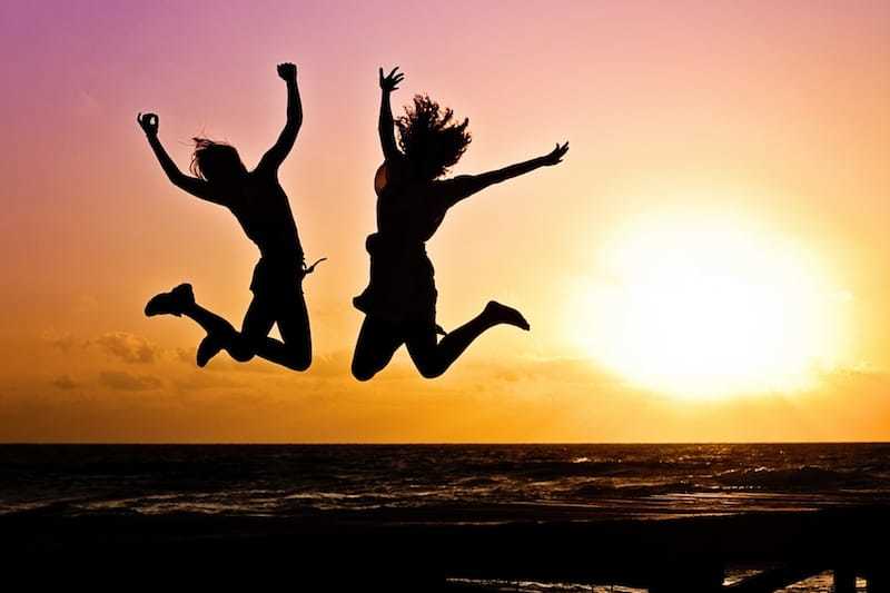 Happy Women jumping for joy at sunset